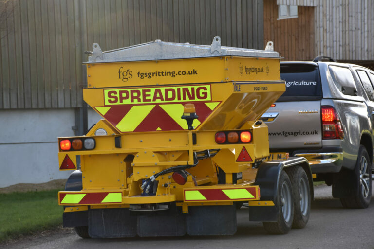 Pickup truck pulling a trailed gritter